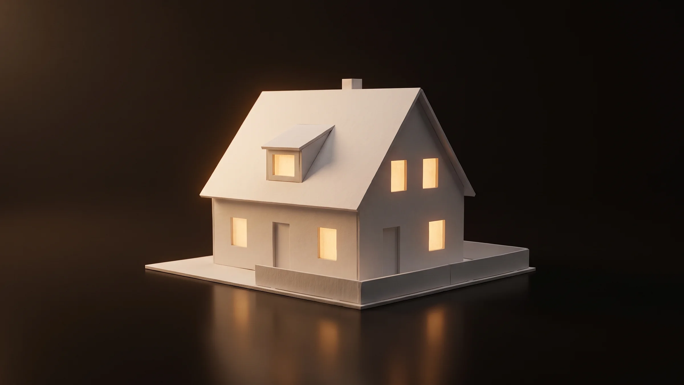 Architekturmodell eines Einfamilienhauses aus Karton am Abend, die Fenster leuchten